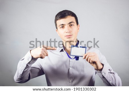 worker stands in id on gray background