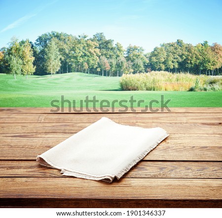 Empty white table cloth on wooden desk mockup. Autumn background. Selective focus.