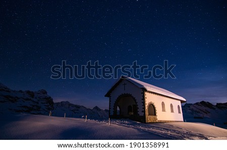beautiful night sky in the swiss alps on a nice winter day with a lovely church in front