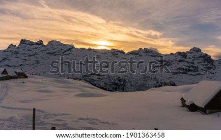 colorful sunrise in the swiss alps in Melchsee-Frutt.  with beautiful mountains, snow and nice clouds