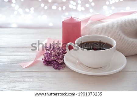 March 8, coffee, a bouquet and a pink candle on a light background. Side view with copy space. The concept of holidays.