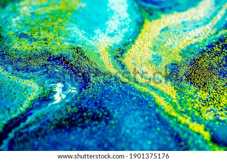 Selective focus. Blue creative abstract painted background, wallpaper, acrylic painting on canvas. Texture art. Blue paint with gold glitter powder. Marble background