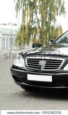 Executive class car, black, with 
beautiful wheels, large chrome grille.