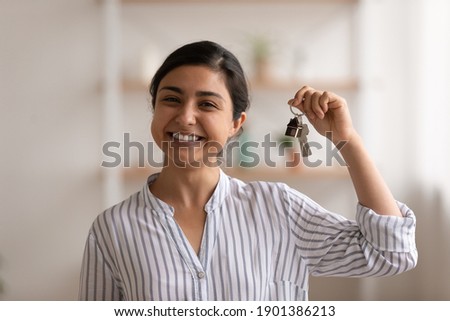 House of dream. Headshot portrait of excited indian female happy winner buyer renter tenant of new home apartment. Young mixed race woman proud homeowner looking at camera showing keys of modern flat Royalty-Free Stock Photo #1901386213