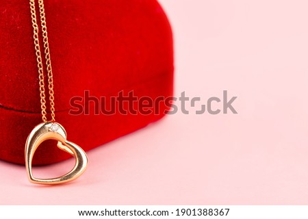 gold heart shaped pendant on red box, pink background, valentine's day, gift Royalty-Free Stock Photo #1901388367