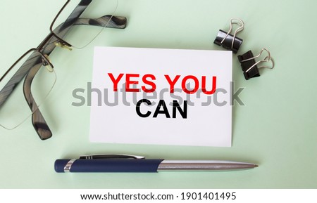 Text Yes You Can on business card with eyeglasses and pen. Concept photo