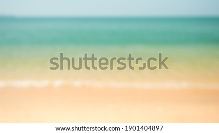 Blur beautiful nature tropical beach with bokeh sun light wave abstract background. Copy space of summer vacation and Summer holiday concept. 