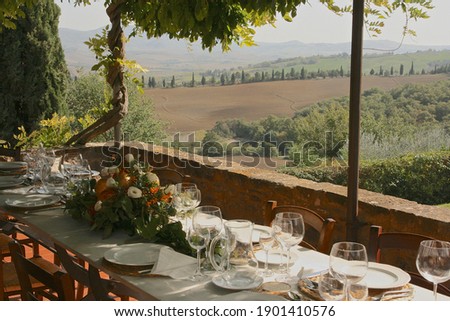 Traditional Tuscan table setting on the terrace  Royalty-Free Stock Photo #1901410576