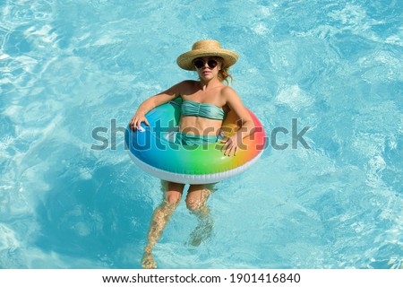 Summer vacation. Woman in swimmingpool. Having fun at aquapark. Swiling girl on inflatable rubber circle. Summertime