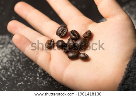 coffee beans in a byby's hand