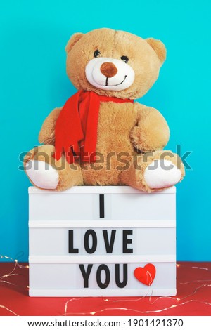 lightbox with text "I love You" and teddy bear on the table