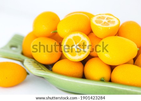 Ripe kumquat fruits on white background