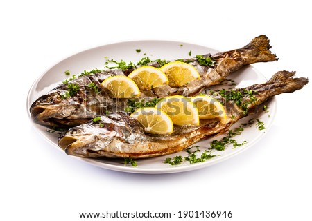 Fish dish - roasted trout with lemon on white background 