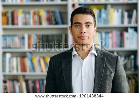 Close-up portrait of confident businessman, student or tutor, indoors. Influential successful hispanic man in formal wear at looks at the camera, show self confidence Royalty-Free Stock Photo #1901438344