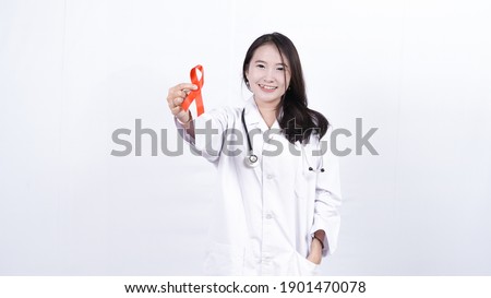 Female doctor holding red cancer awareness ribbon