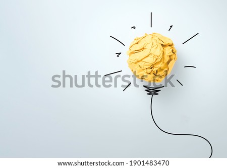 Yellow scrap paper ball with illustration painting for virtual lightbulb. It is creative thinking idea and innovation concept.