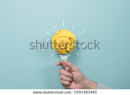 Businessman holding yellow scrap paper ball with illustration painting for virtual lightbulb. It is creative thinking idea and innovation concept. Royalty-Free Stock Photo #1901483485