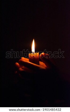 burning candle in his hand, a prayer in the church. The Christian faith. Royalty-Free Stock Photo #1901485432