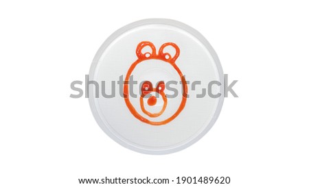 Teddy bear is drawn with ketchup on a plate, teddy bear in a plate is isolated on a white background, cute bear is drawn with sauce.