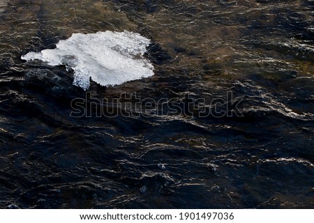 Ice and dark water with waves