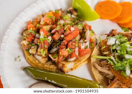 Fish and Carnitas Taco on a orange table