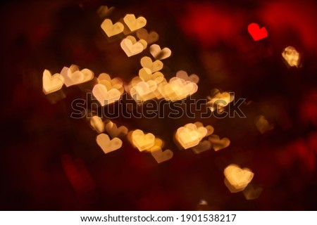 Blurred view of heart shaped lights on black background. Bokeh effect. Valentine Day.