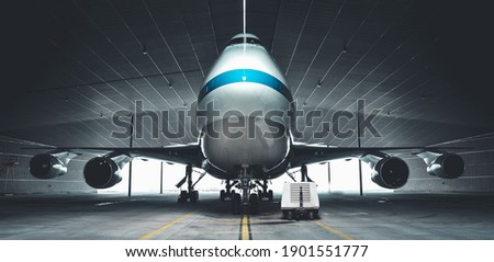 Airplane parking in a hanger inside airport . Elements of this image furnished by NASA Royalty-Free Stock Photo #1901551777