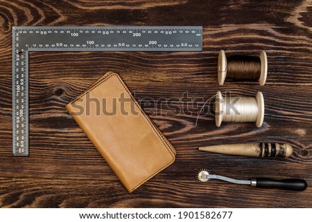 handmade leather wallet with tools from the workshop. genuine leather accessory