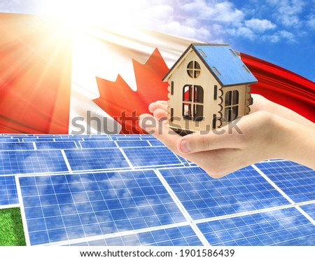 The photo with solar panels and a woman's palm holding a toy house shows the flag of Canada in the sun.