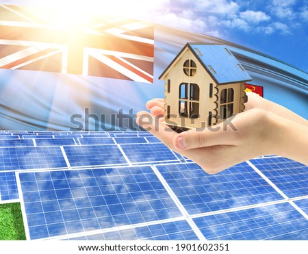 The photo with solar panels and a woman's palm holding a toy house shows the flag of Fiji in the sun.