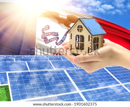 The photo with solar panels and a woman's palm holding a toy house shows the flag State of Iowa in the sun.