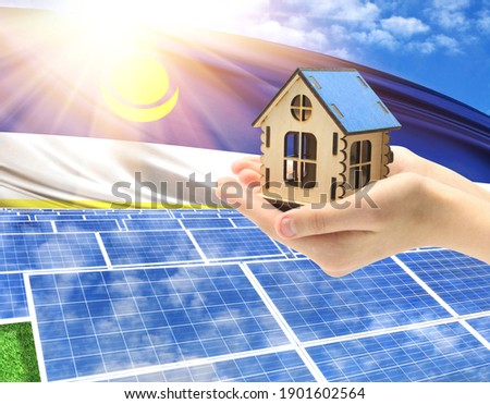 The photo with solar panels and a woman's palm holding a toy house shows the flag of Buryatia in the sun.