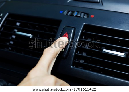 Close up hand press the emergency light in the car, Fingers press button.for open the contract emergency light in car. Emergency button press for open emergency light warning sign symbol out side car