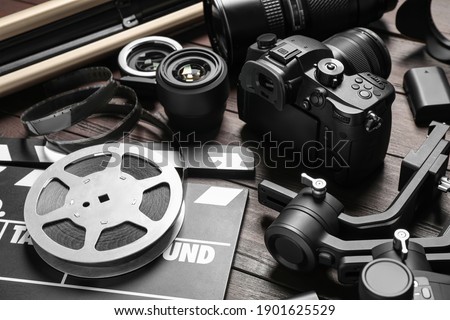 Modern camera and video production equipment on brown wooden table