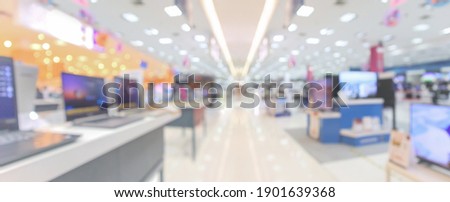 Laptop computer and television in electronic department store blurred background