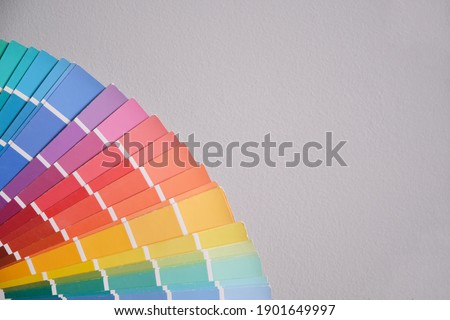 Old color palette guide catalogue on a gray wall. House painter tool concept.