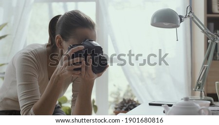 Professional photographer working from home, she is taking pictures of table setting with teapot