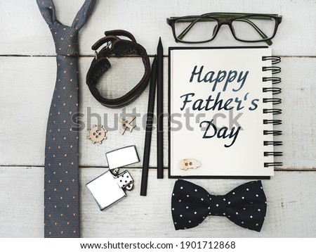 Notebook for congratulating your father, glasses, pencil, pen on a beautiful, white table. Top view of a close-up. Preparation for the holiday