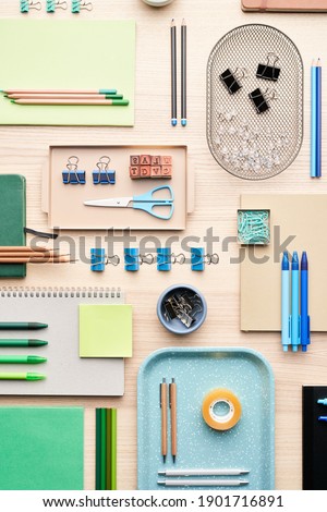 Flat lay of various colorful stationery placed in order on desk in office