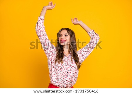 Photo of adorable person raise hands dancing look empty space isolated on vivid yellow color background