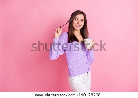 Photo of optimistic girl hold cup look empty space wear lilac sweater trousers isolated on pink color background