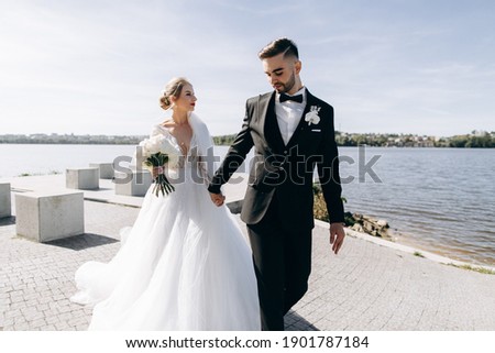 Bride and groom on their wedding day near the river. Classic wedding portrait