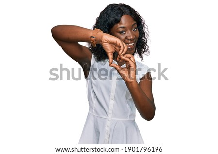 Beautiful african young woman wearing casual clothes smiling in love doing heart symbol shape with hands. romantic concept. 
