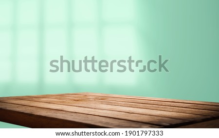Empty table top made of natural wood, light
rays from the window on the background of the wall. For product demonstration