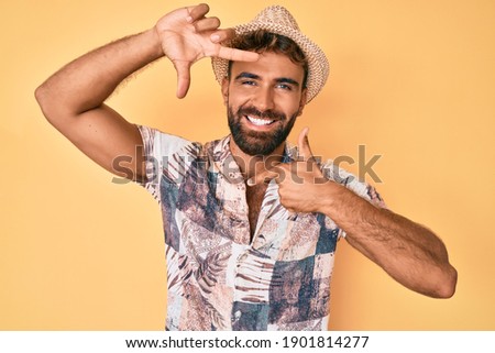 Young hispanic man wearing summer hat smiling making frame with hands and fingers with happy face. creativity and photography concept. 
