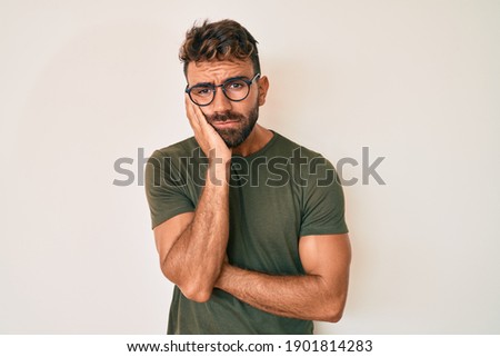 Young hispanic man wearing casual clothes and glasses thinking looking tired and bored with depression problems with crossed arms. 