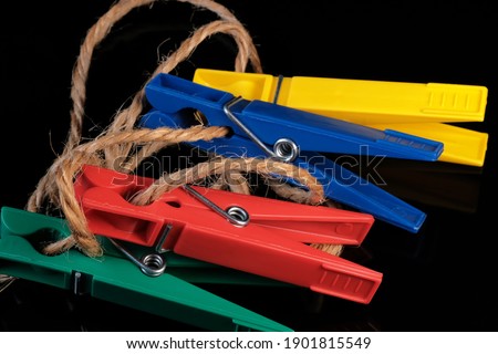 Colored composition on black mirrored background with clothespins close-up macro photography