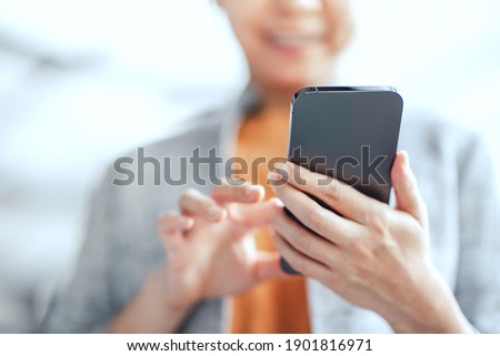 Happy female using smartphone at modern coffee shop, she chatting Online Messaging on mobile. Social media concept. Royalty-Free Stock Photo #1901816971