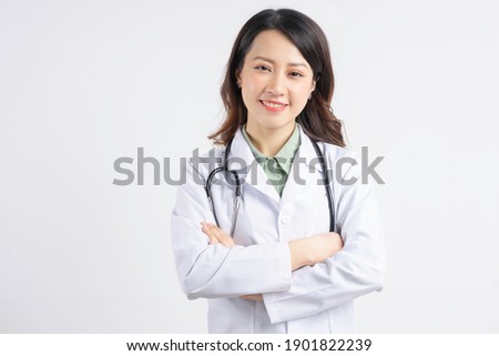 Portrait of Asian female doctor holding hands and smiling
 Royalty-Free Stock Photo #1901822239