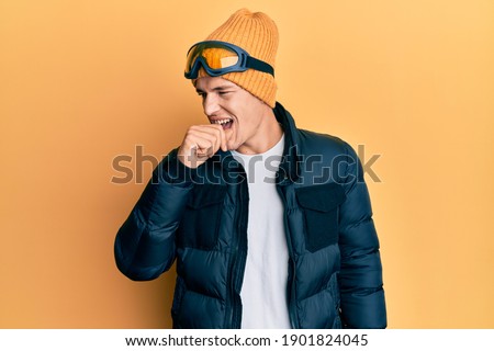 Handsome caucasian man wearing snow wear and sky glasses feeling unwell and coughing as symptom for cold or bronchitis. health care concept.  Royalty-Free Stock Photo #1901824045